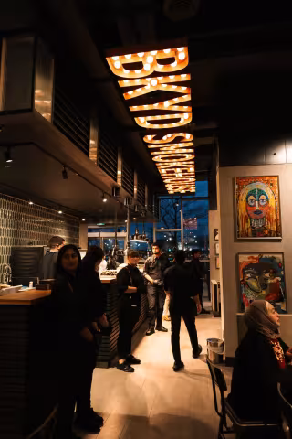 Illuminated BKYD Smokehouse marquee sign and dining area at Backyard Smokehouse Mississauga