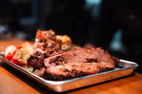 Sliced smoked brisket served on a metal tray at Backyard Smokehouse Mississauga