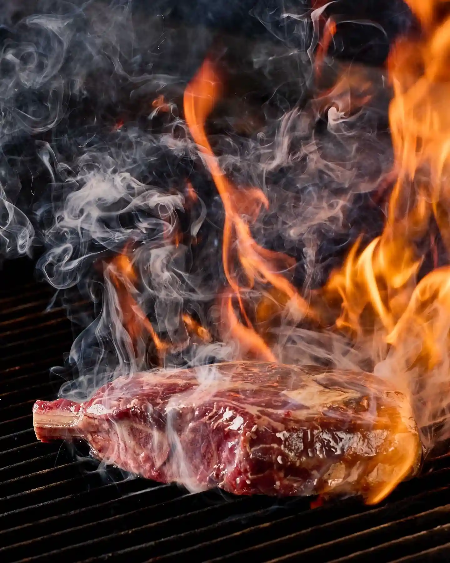 Best BBQ takeout Edmonton — Fresh BBQ meat being prepared over high-heat grill flames