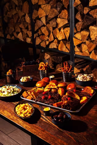 Backyard Smokehouse Edmonton pulled brisket sliders with cornbread on dark slate board under warm light